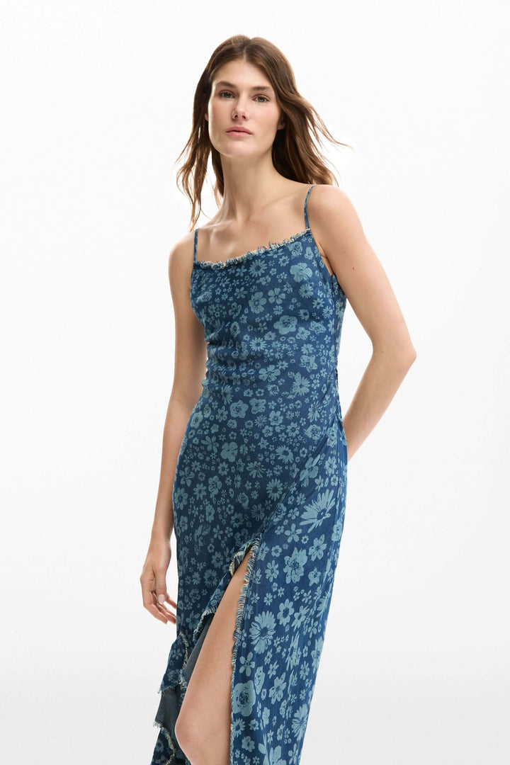 Femme portant une robe à volants en denim à bretelles fines, coupe ajustée idéale pour une tenue élégante.