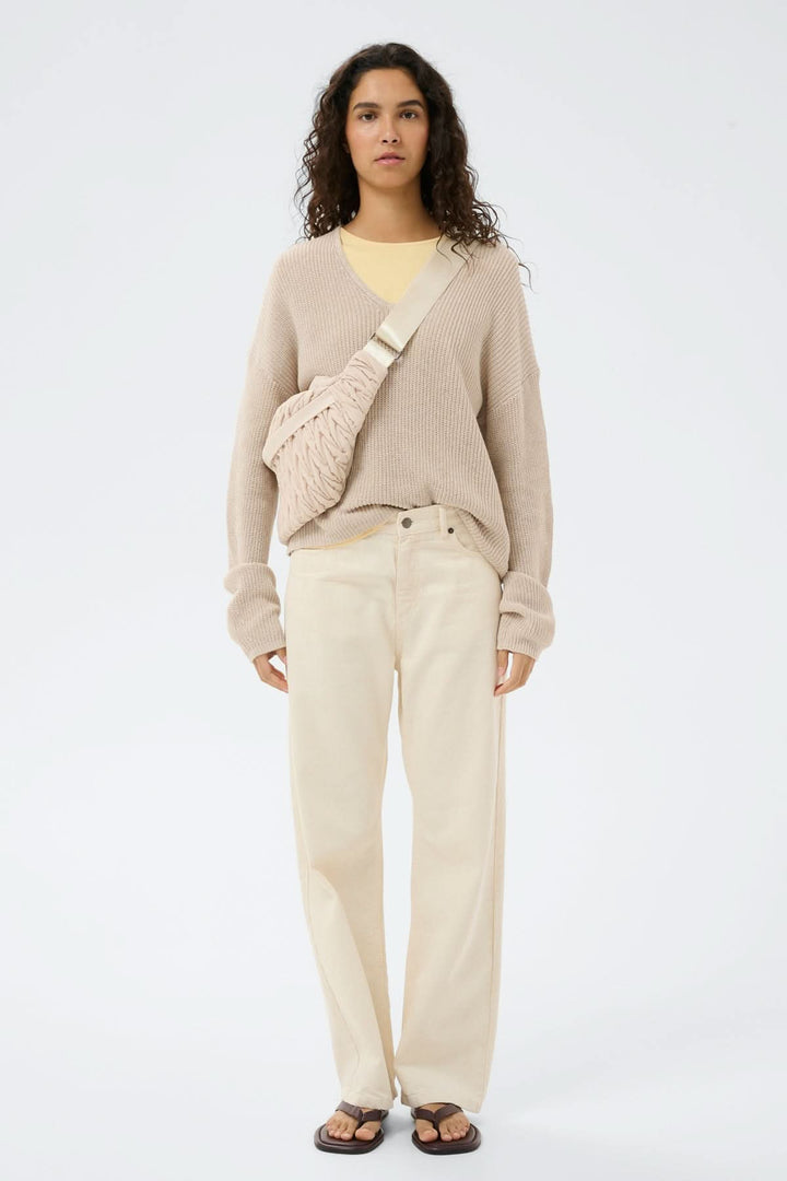 Sac bandoulière matelassé Samy Bumbag sur modèle, texture froncée, bandoulière ajustable, complète une tenue urbaine et décontractée.
