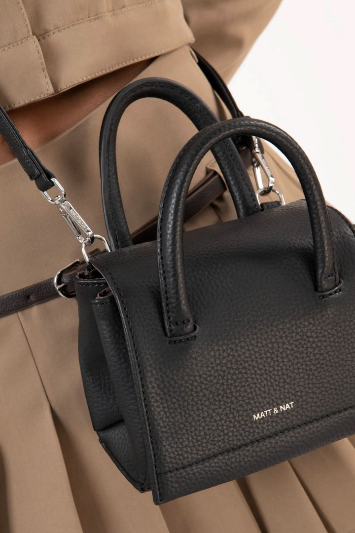 Sacoche Adelmicro vegan noire avec double poignées et bandoulière ajustable, idéale pour une tenue chic.