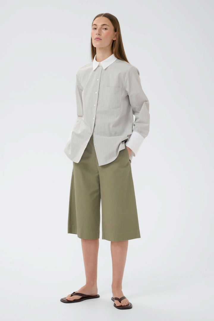 Modèle portant le Short bermuda structuré Diazi de couleur olive, coupe moderne et épurée, parfait pour un look polyvalent et soigné.
