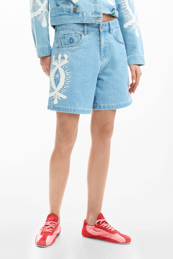 Short en jean brodée en denim, coupe droite avec broderies graphiques, parfait pour un style estival tendance et polyvalent.