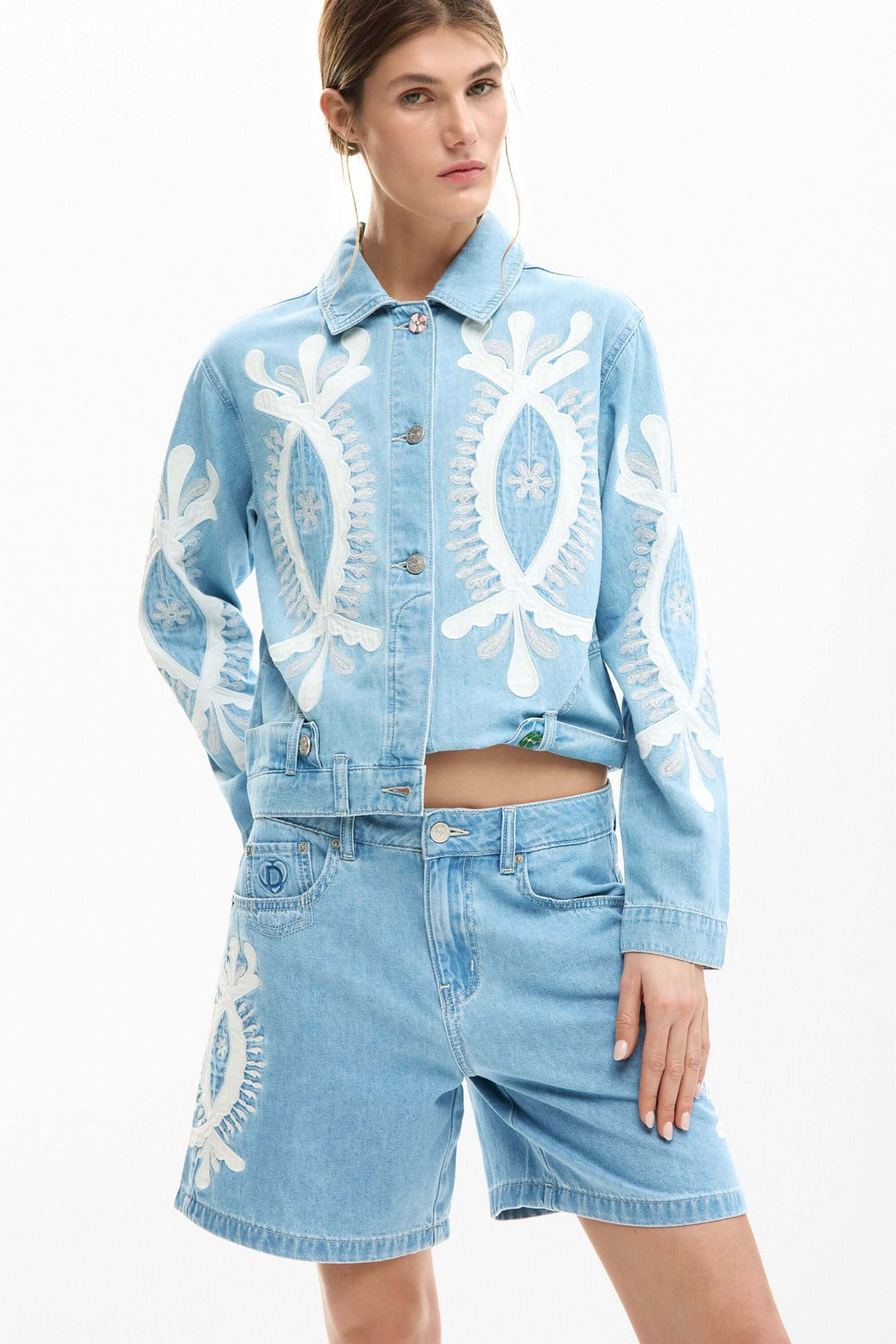 Short en jean brodée en denim bleu avec broderies sur le devant, porté avec une veste coordonnée, style d&