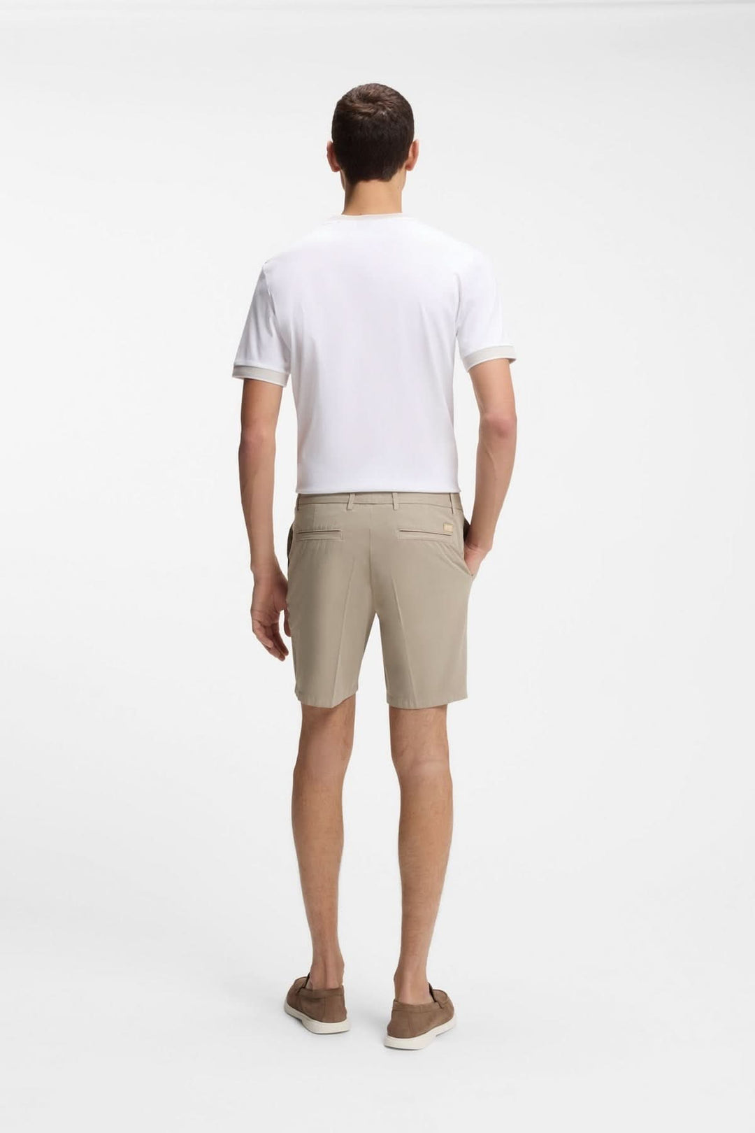 Homme portant un short structuré à coupe droite beige avec t-shirt blanc, vu de dos, idéal pour un look estival moderne.