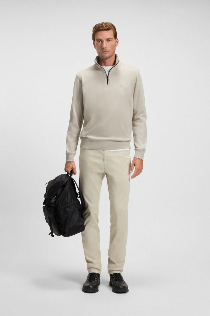 Homme portant un Sweatshirt à demi-zip en coton éponge BOSS, beige, look casual chic avec sac à dos noir.