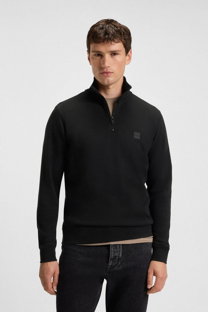 Homme portant le Sweatshirt à demi-zip en coton éponge BOSS noir, coupe régulière, col montant, manches longues, style décontracté chic.