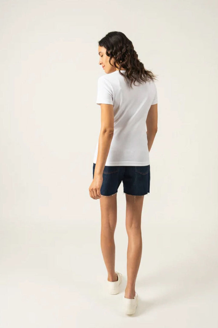 Femme portant un t-shirt blanc AJACCIO II avec shorts, vue arrière, style décontracté et moderne.