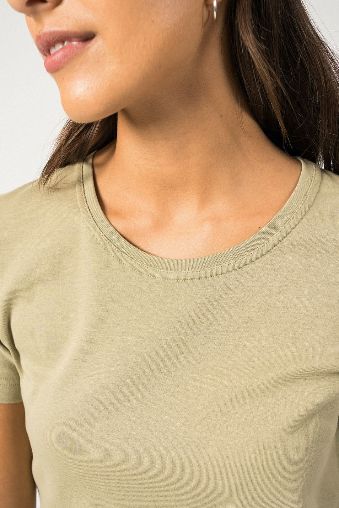 Détail d'un t-shirt AJACCIO II beige, avec col rond et manches courtes, porté par une femme.