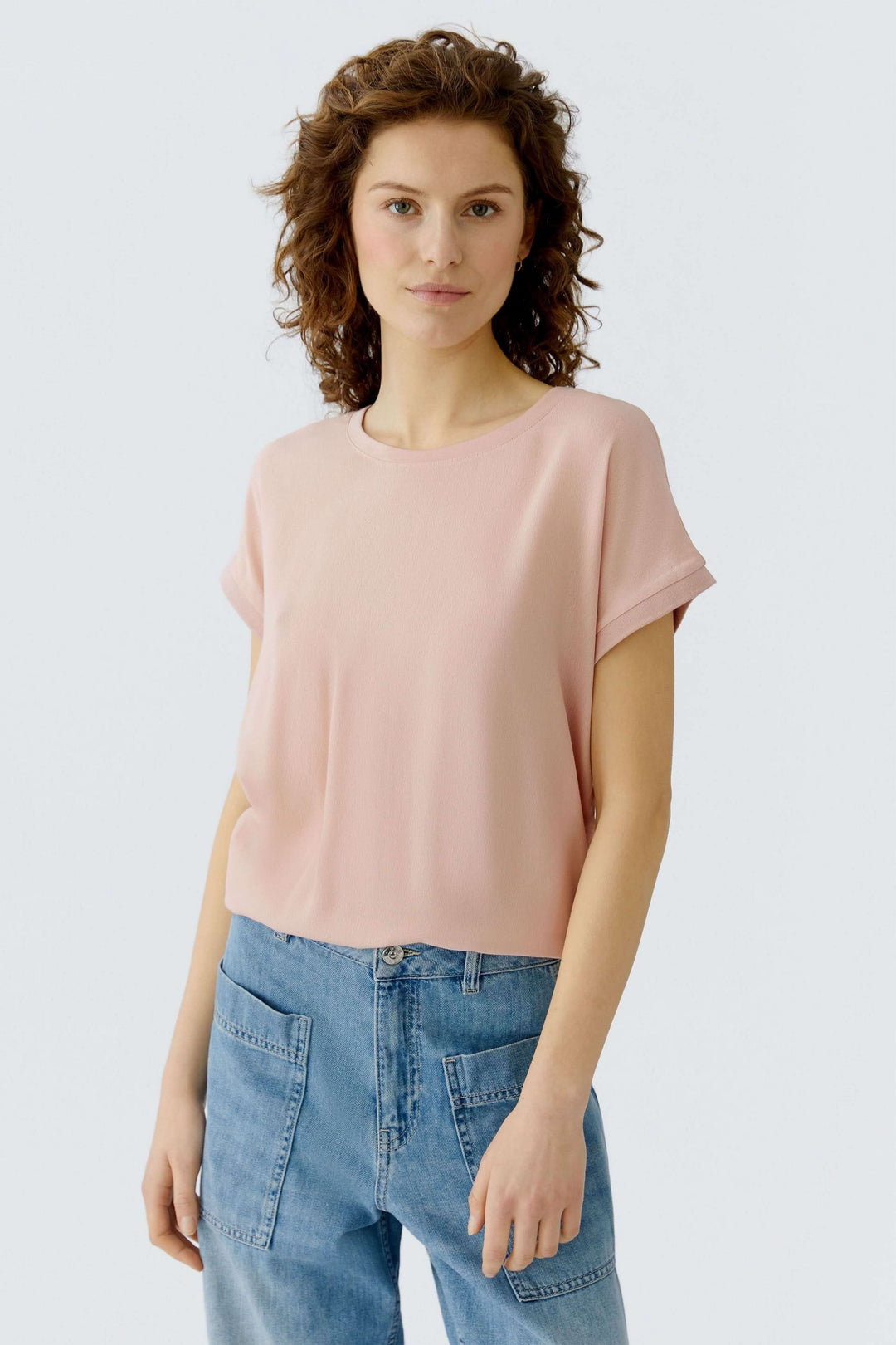 Femme portant le T-shirt Ayano rose, coupe droite, encolure ronde, manches courtes avec revers, tombé fluide et léger.