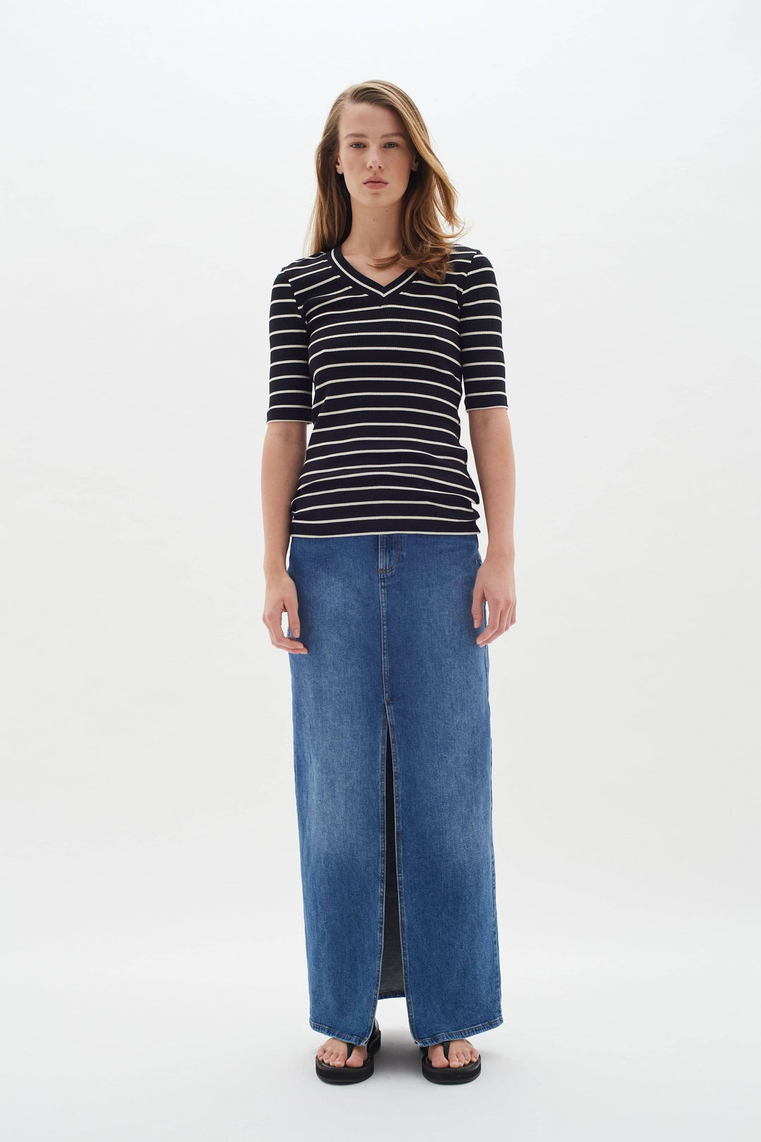 T-shirt Dagna à rayures noires et blanches, coupe ajustée, porté avec une jupe longue en denim.
