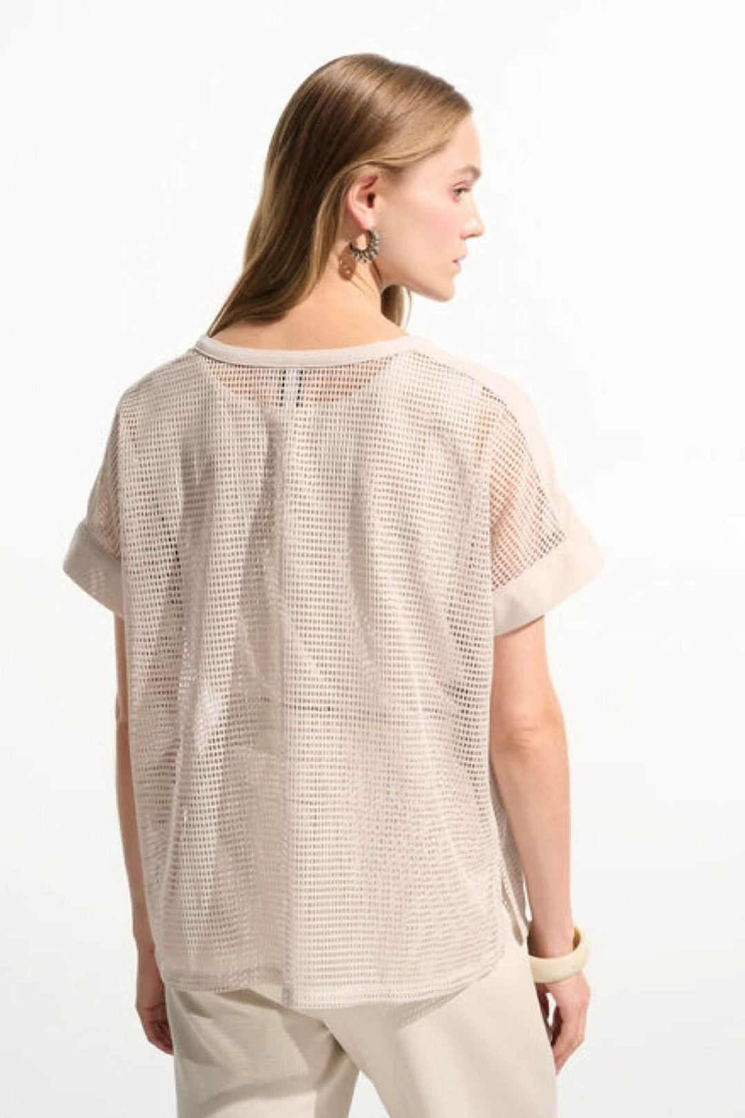 Femme portant un T-shirt ajouré fluide beige avec maille quadrillée et manches courtes, vue de dos. Look moderne et décontracté.