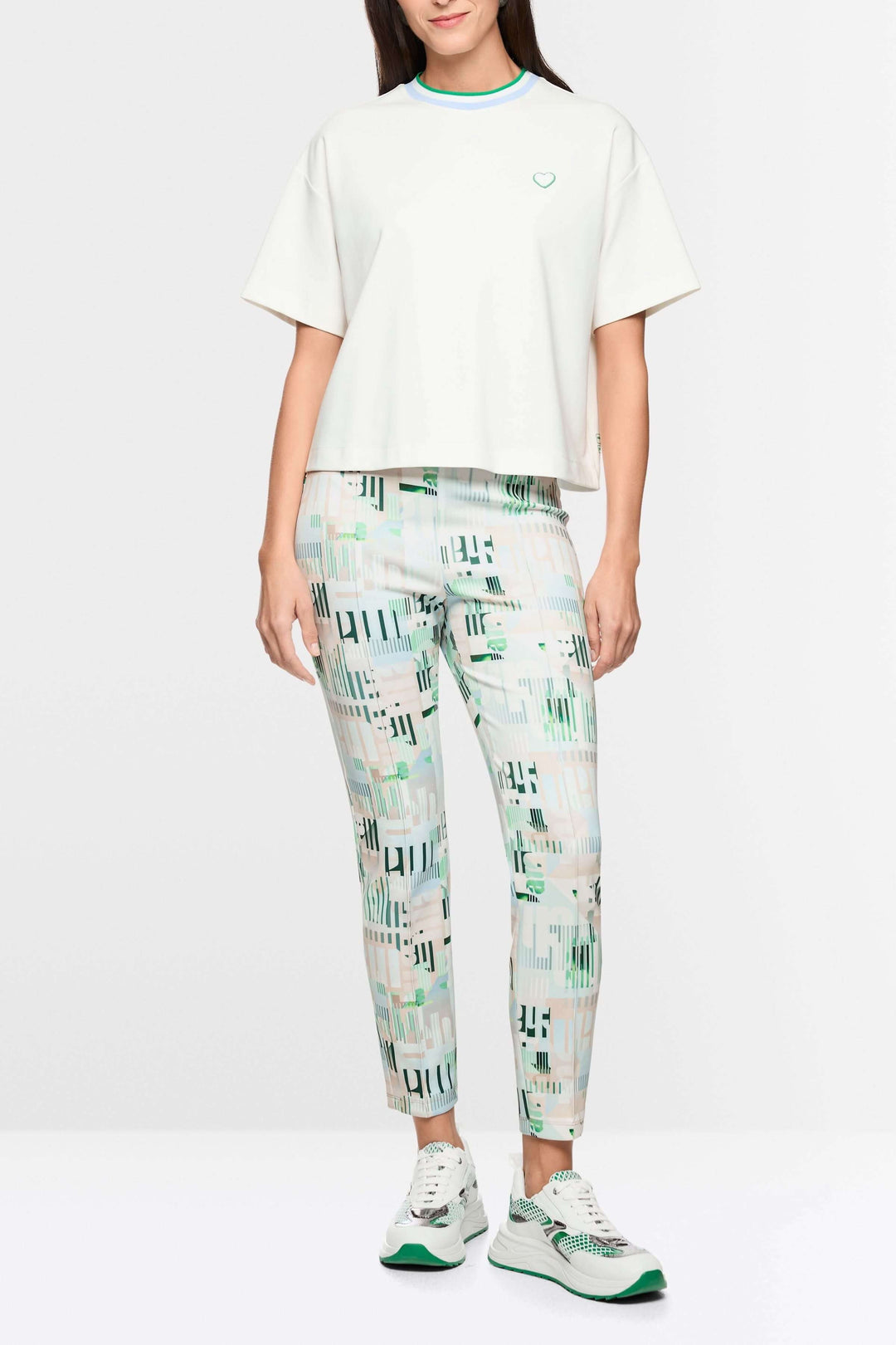 Femme portant un t-shirt avec détails en forme de cœur et à rayures, coupe ample, manches larges, encolure ronde avec liseré contrastant.