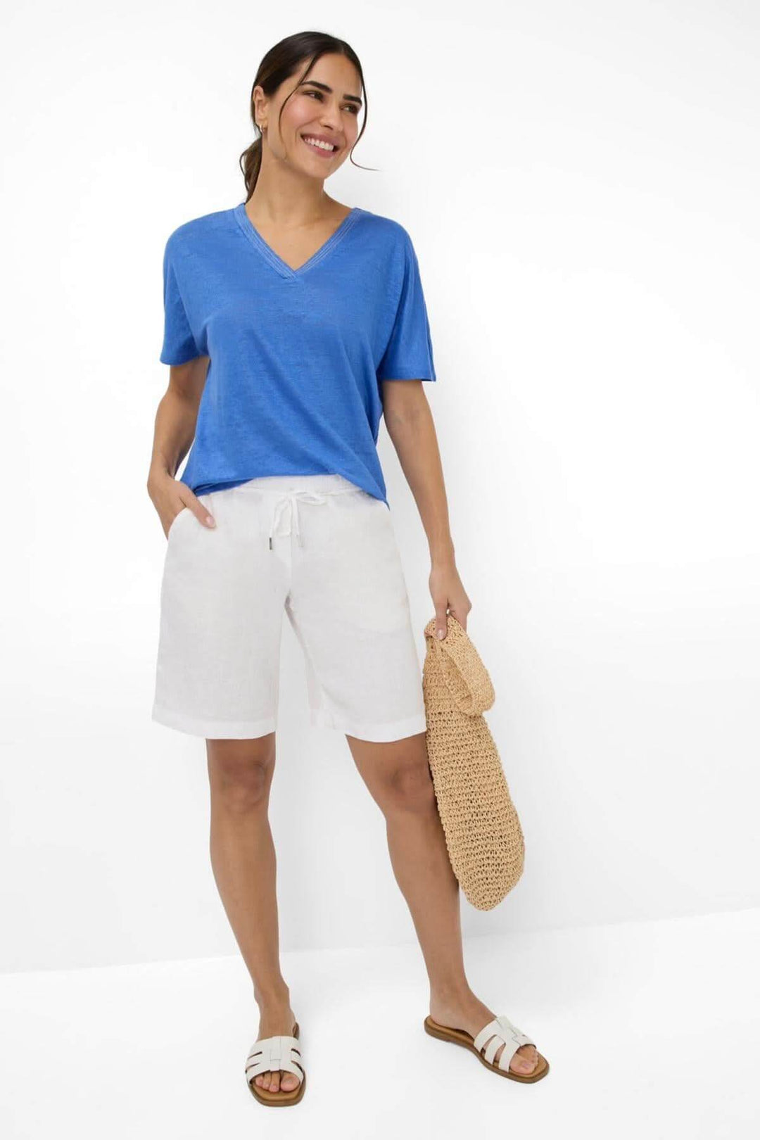Femme en T-shirt col V bleu avec shorts clairs, tenue décontractée idéale pour l&