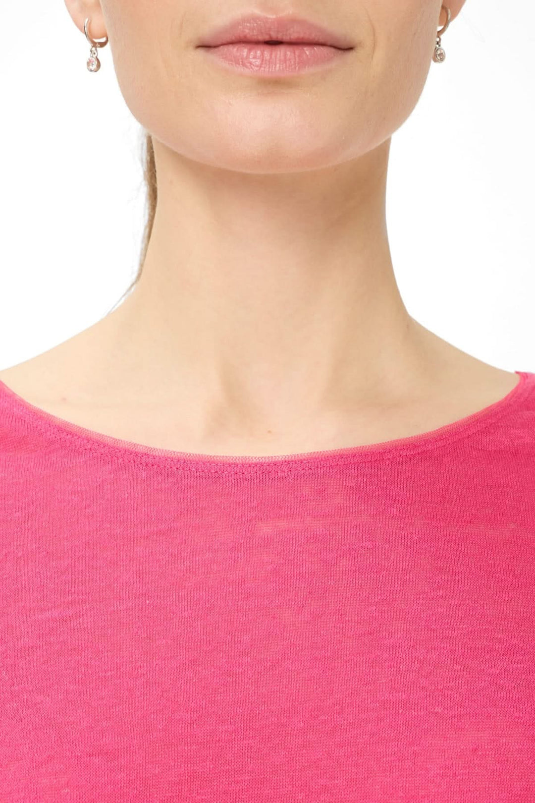 Femme portant un T-shirt col bateau Caelen rose avec encolure dégagée, style moderne et confortable.