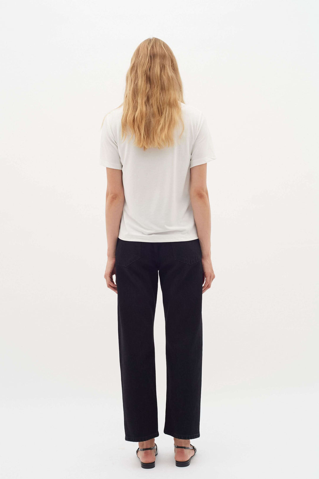 Modèle vue de dos portant un t-shirt col rond Liliana en tissu doux, associé à un pantalon noir.