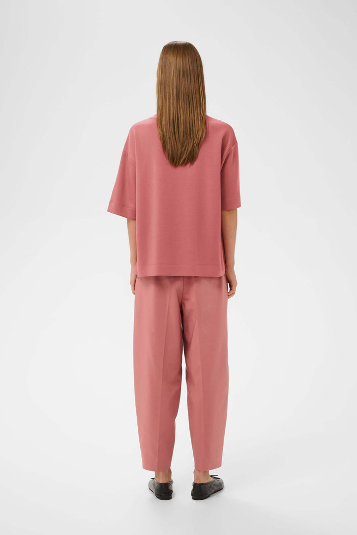Vue arrière du T-shirt coupe ample Pannie rose porté avec un pantalon coordonné, manches courtes et encolure ronde.