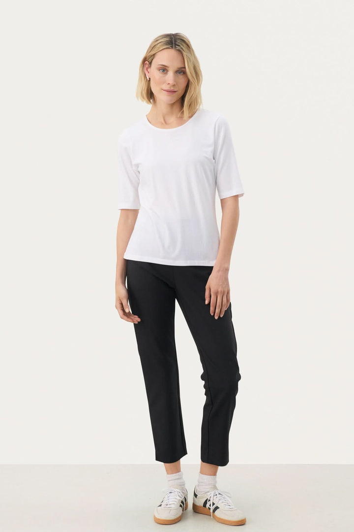 Femme portant un T-shirt coupe droite Nemi blanc, style minimaliste et confortable, adapté à un look moderne et quotidien.