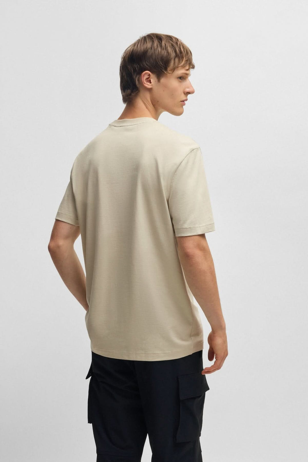 T-shirt de coton beige avec logo texturé, coupe régulière, porté par un homme vue de dos.