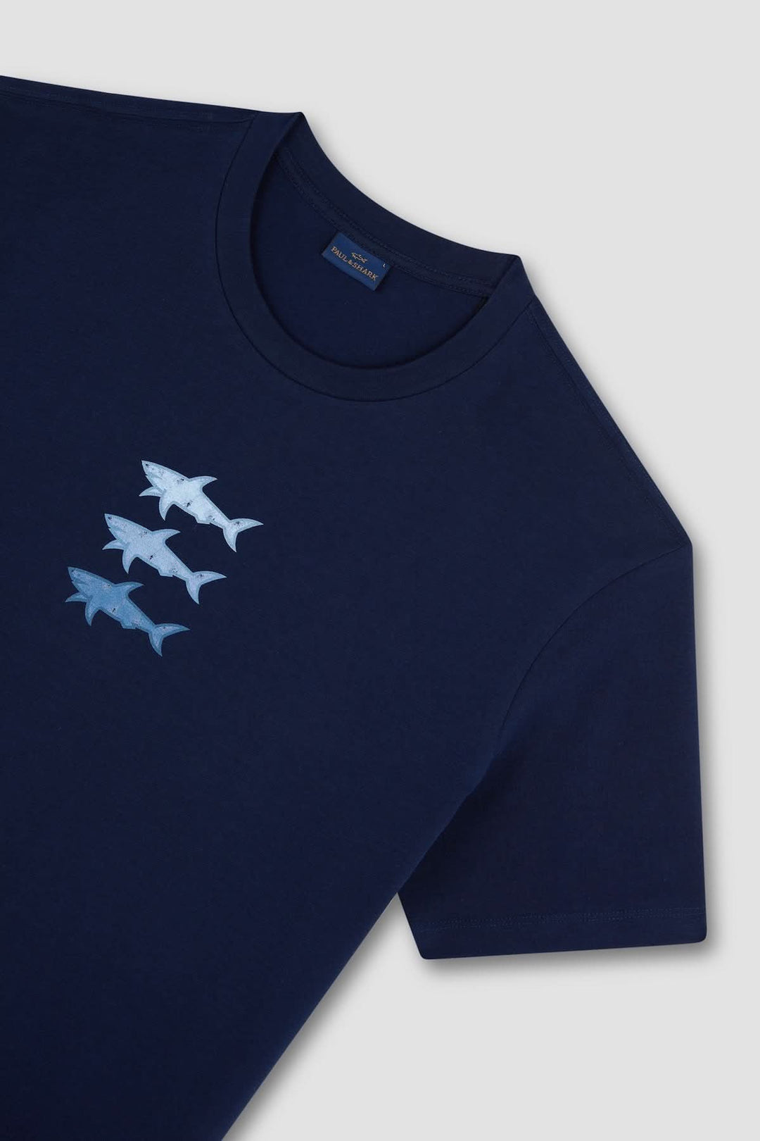 T-shirt en coton bleu marine avec imprimé de trois requins stylisés sur la poitrine.