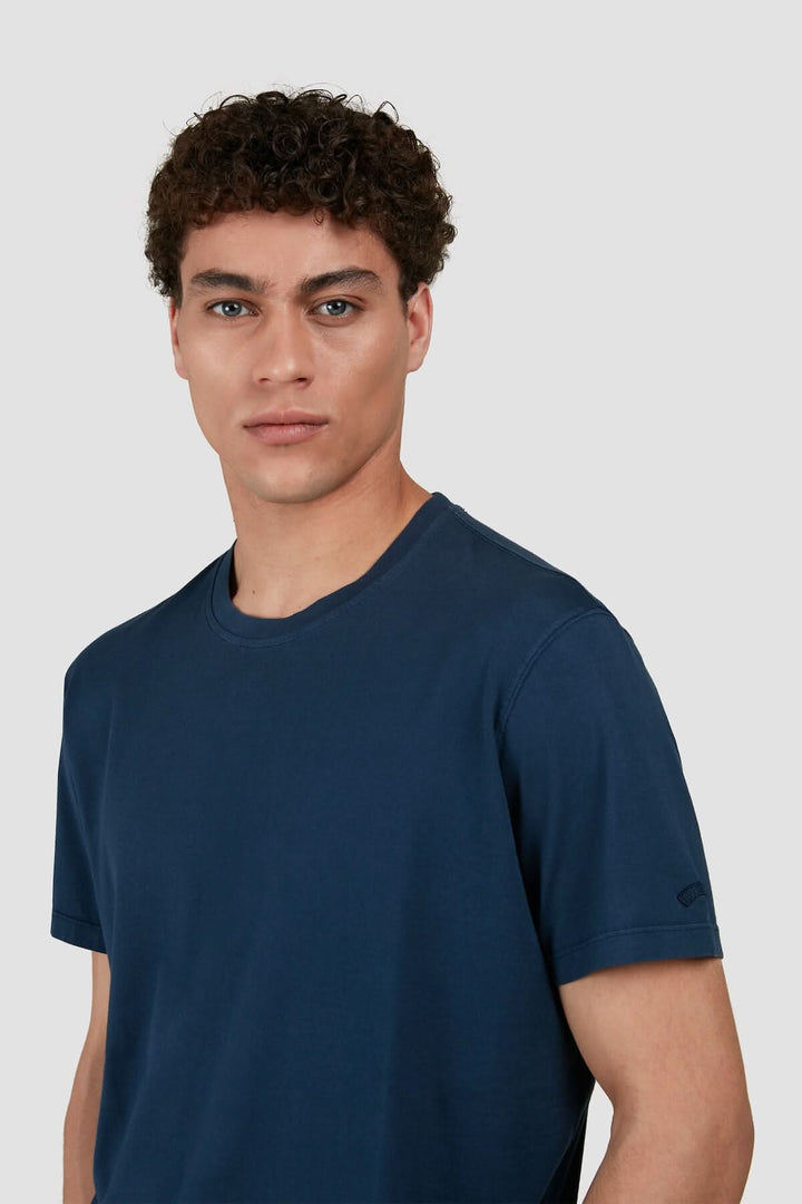 Homme portant un t-shirt en coton uni de Paul & Shark, couleur bleu marine, avec un logo brodé.