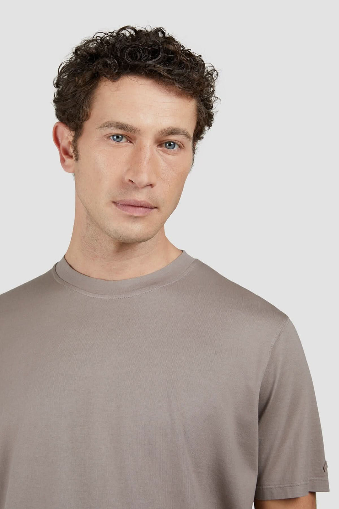 Homme portant un t-shirt en coton uni marron, design minimaliste et élégant, parfait pour un style décontracté.