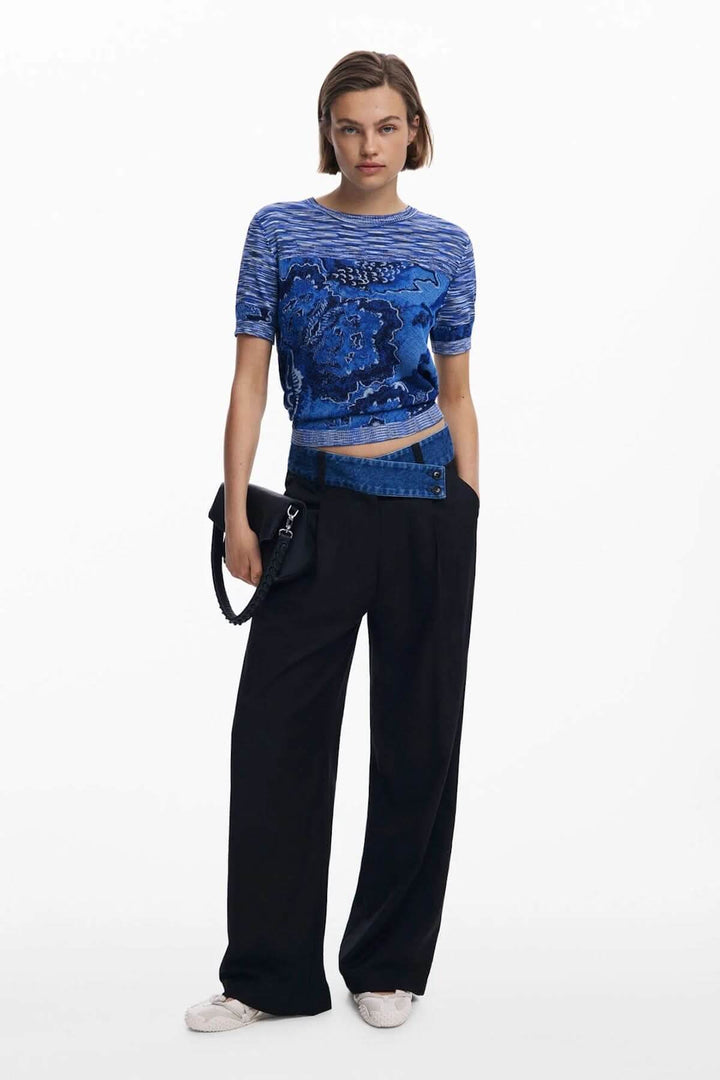 Femme portant un T-shirt en tricot avec motif carte topographique, style moderne avec pantalon taille haute.