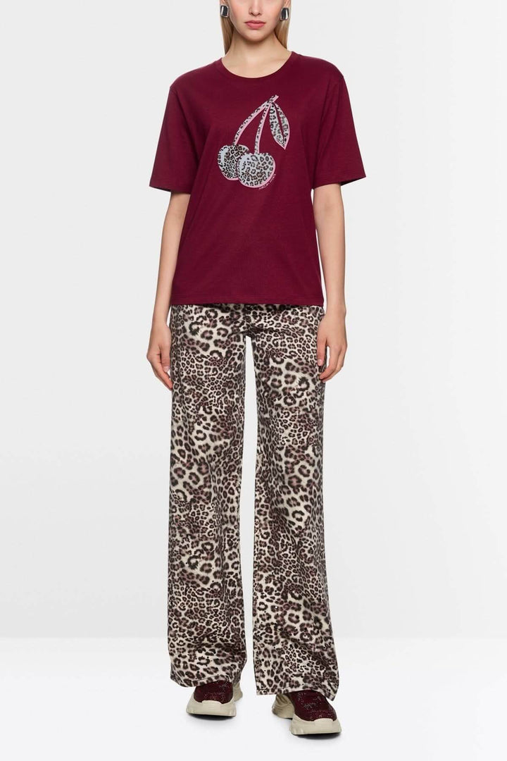 T-shirt imprimé cerises léopard, femme portant le t-shirt en coton biologique avec motif cerises léopard et coupe droite, encolure ronde.