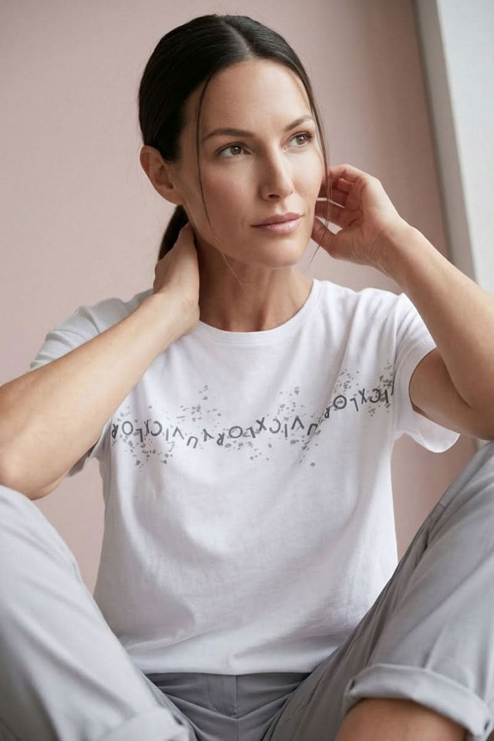 Femme portant un T-shirt imprimé graphique avec manches courtes et encolure ronde dans un style décontracté.
