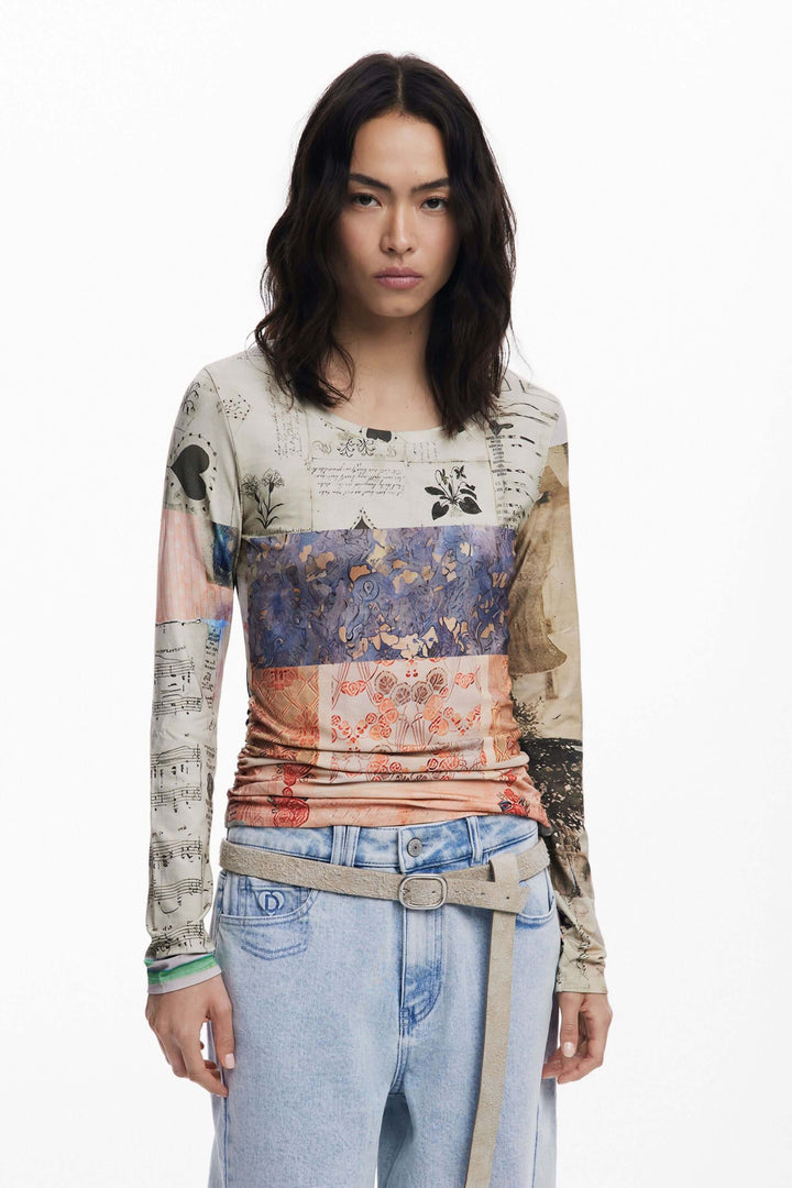 Femme portant un T-shirt imprimé patchwork avec manches longues et motifs artistiques, assorti à un jean décontracté.