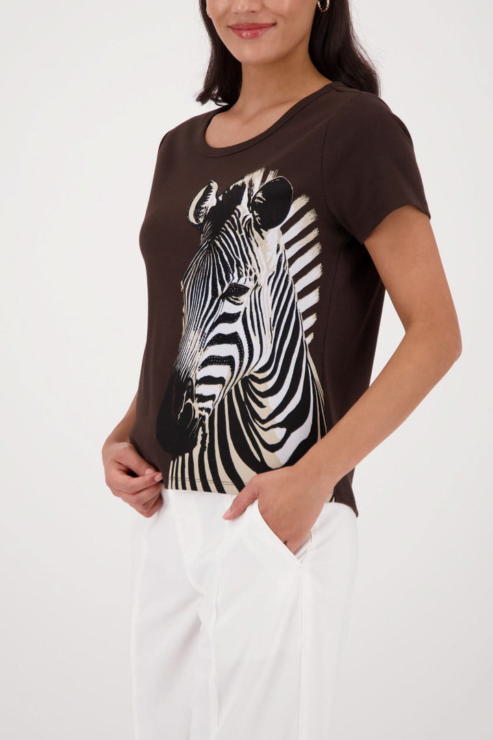 Femme portant un t-shirt imprimé zèbre avec un design audacieux, parfait pour un look moderne et graphique.
