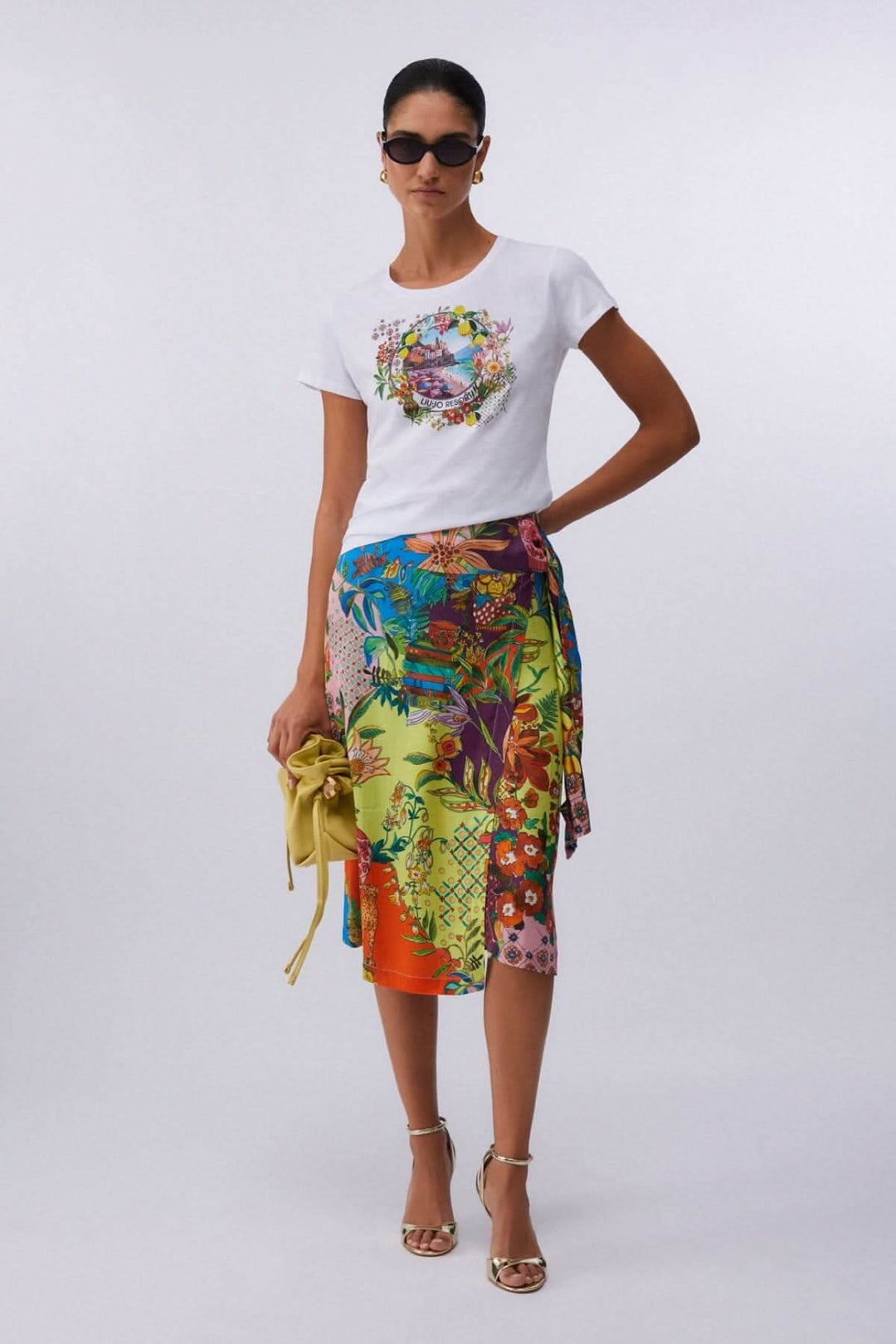 Mode avec t-shirt à manches courtes avec imprimé graphique, jupe colorée et accessoires tendance, style décontracté et féminin.