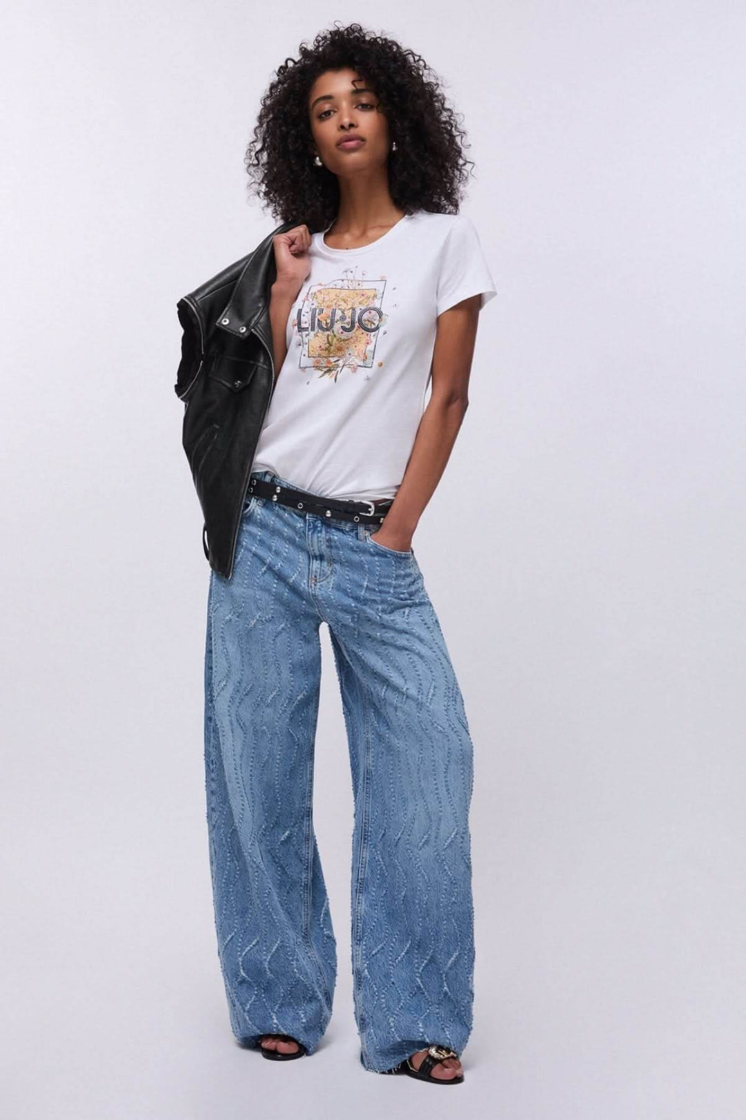T-shirt à manches courtes avec imprimé graphique sur mannequin, look décontracté avec jean et veste.