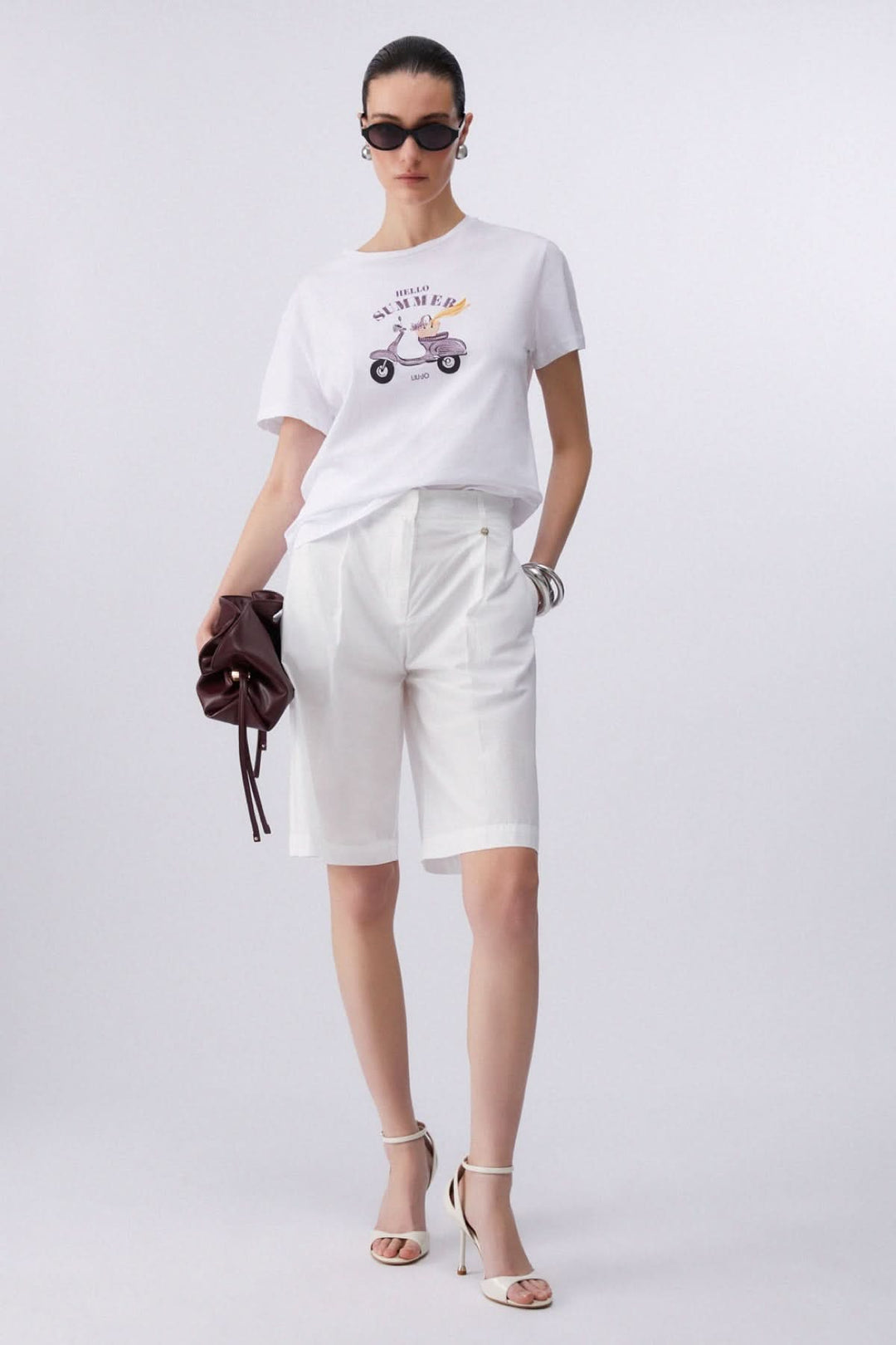 Femme portant un T-shirt à manches courtes avec imprimé graphique, style moderne et décontracté, tenue estivale élégante.