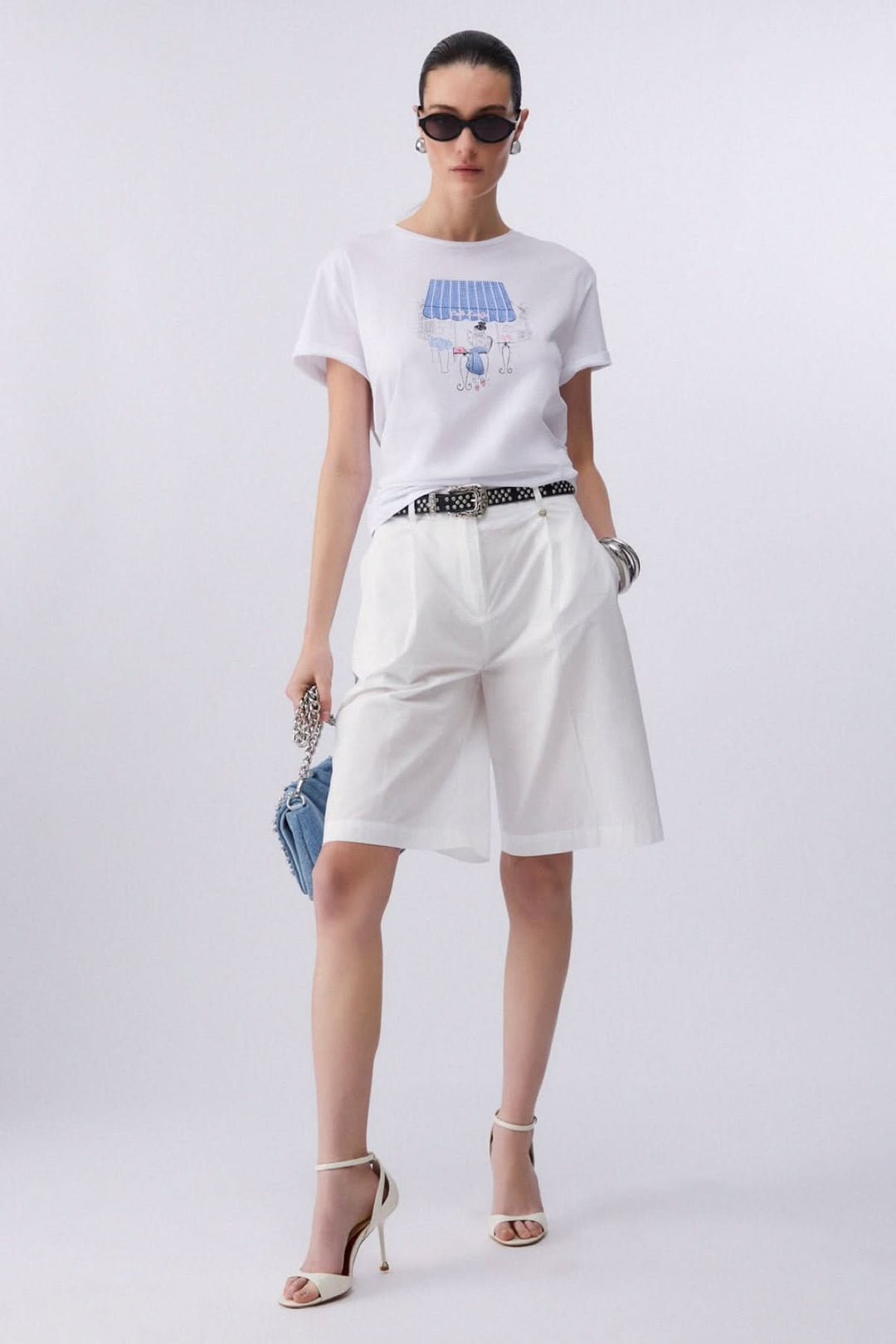 Femme portant un t-shirt à manches courtes avec imprimé graphique, style moderne et féminin, tenue décontractée et stylée.