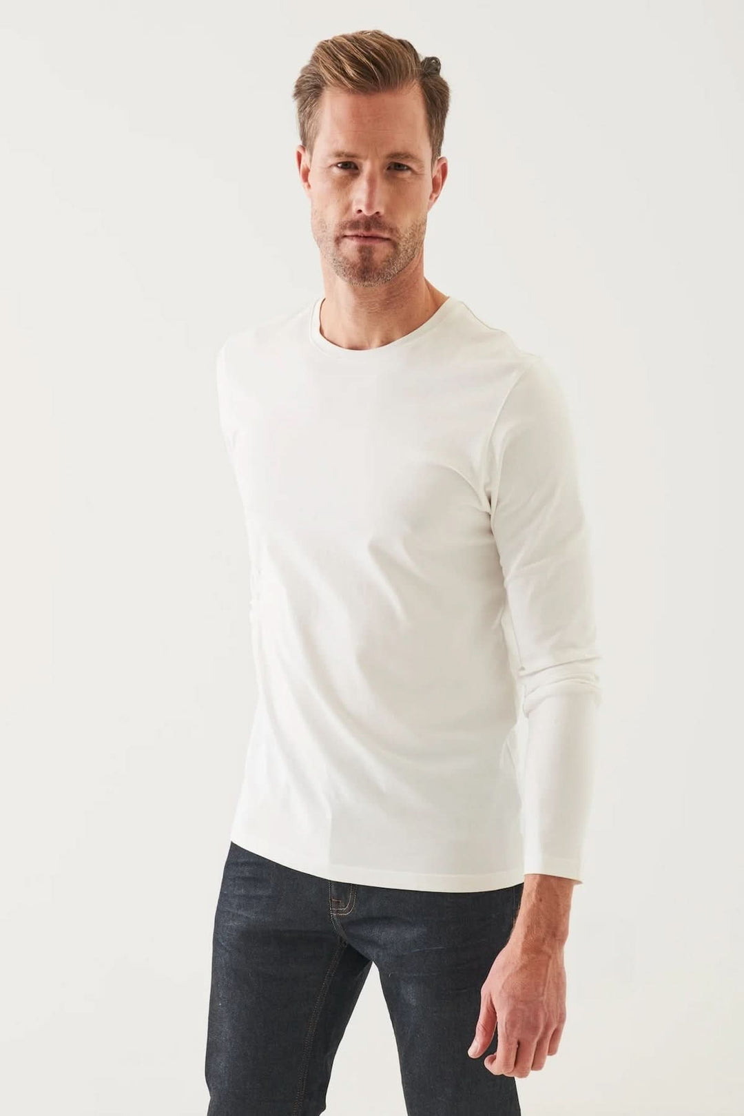 Homme portant un t-shirt à manches longues blanc en coton Pima, parfait pour un style décontracté.