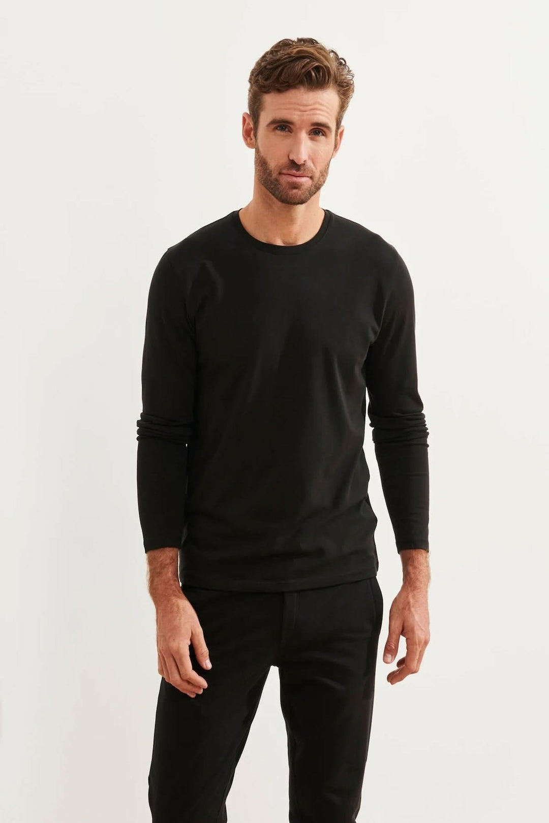 Homme portant un t-shirt à manches longues noir en tissu de coton Pima, parfait pour un look décontracté.