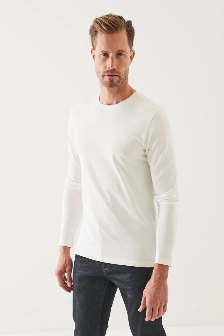 Homme portant un t-shirt manches longues blanc, col rond, en coton Pima extensible.
