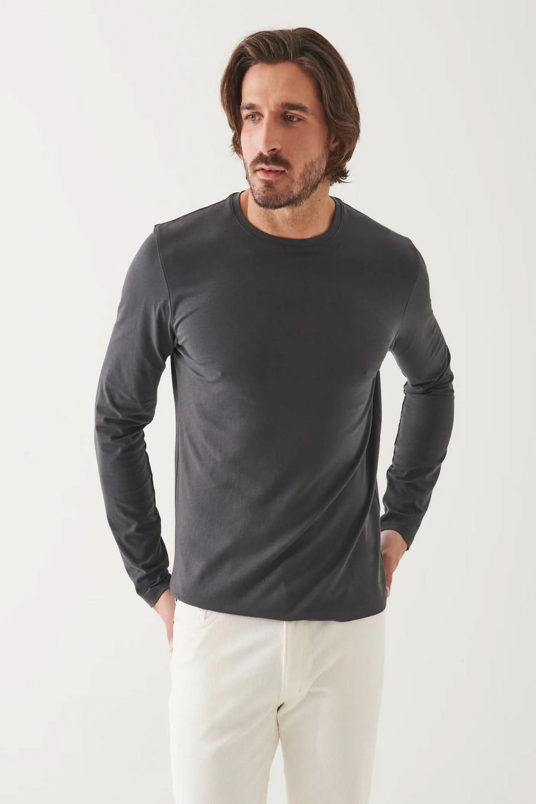 Homme portant un t-shirt à manches longues gris en coton Pima, col rond, devant un fond blanc.