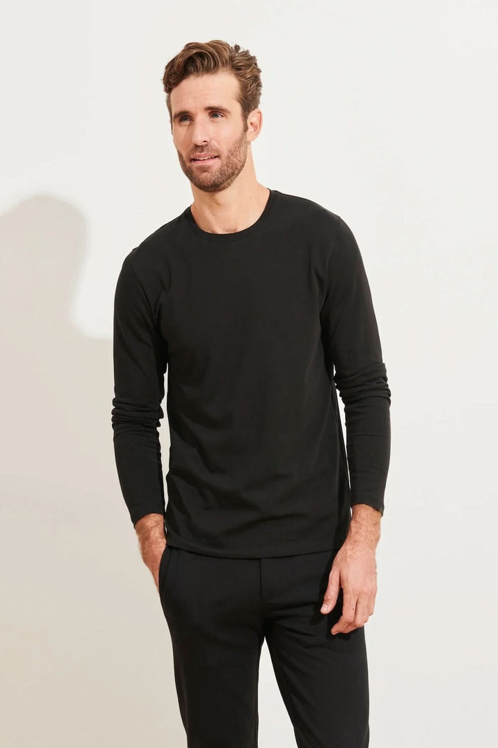 Homme portant un t-shirt noir à manches longues et col rond en coton Pima, idéal pour le confort quotidien.