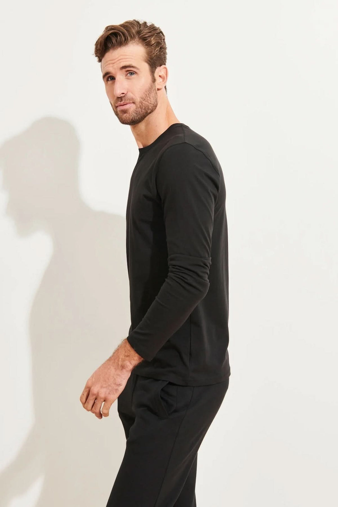 Homme portant un t-shirt noir à manches longues en coton Pima, élégant et confortable.