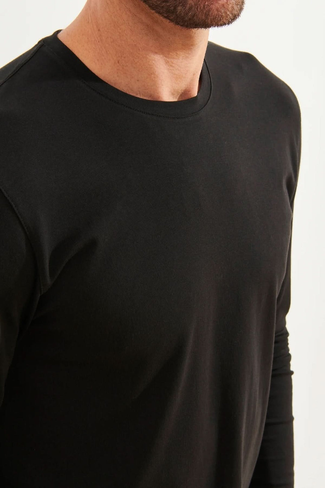 T-shirt noir à manches longues en coton Pima, col rond, fait pour le confort et la polyvalence.