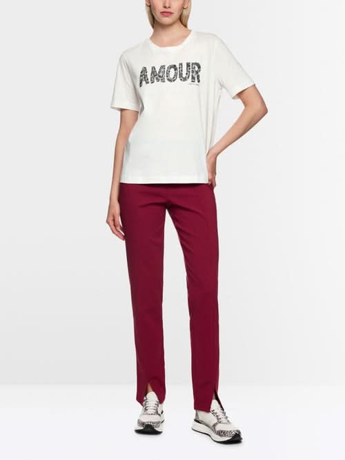 Femme portant un T-shirt à paillettes avec slogan "Amour", col rond, manches courtes, confortable en coton, coupe décontractée.