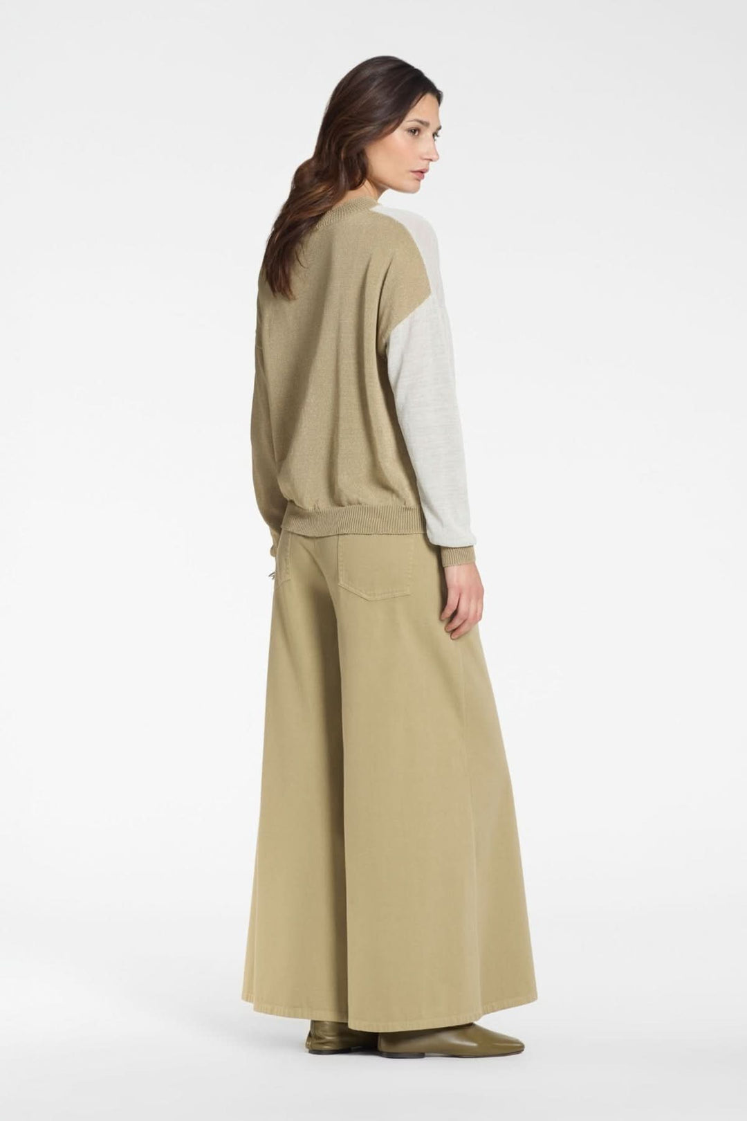 Femme portant un tricot bicolore en maille légère avec coupes fluides et manches longues.