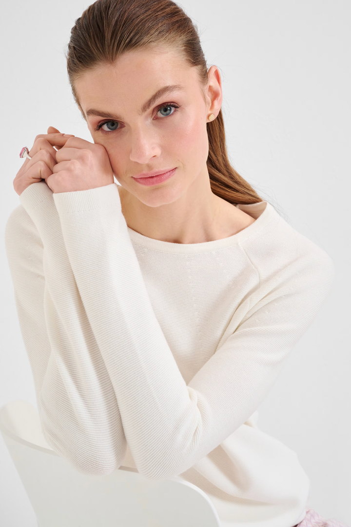 Femme souriante portant un tricot col rond Lesley, élégant et confortable pour l'automne.