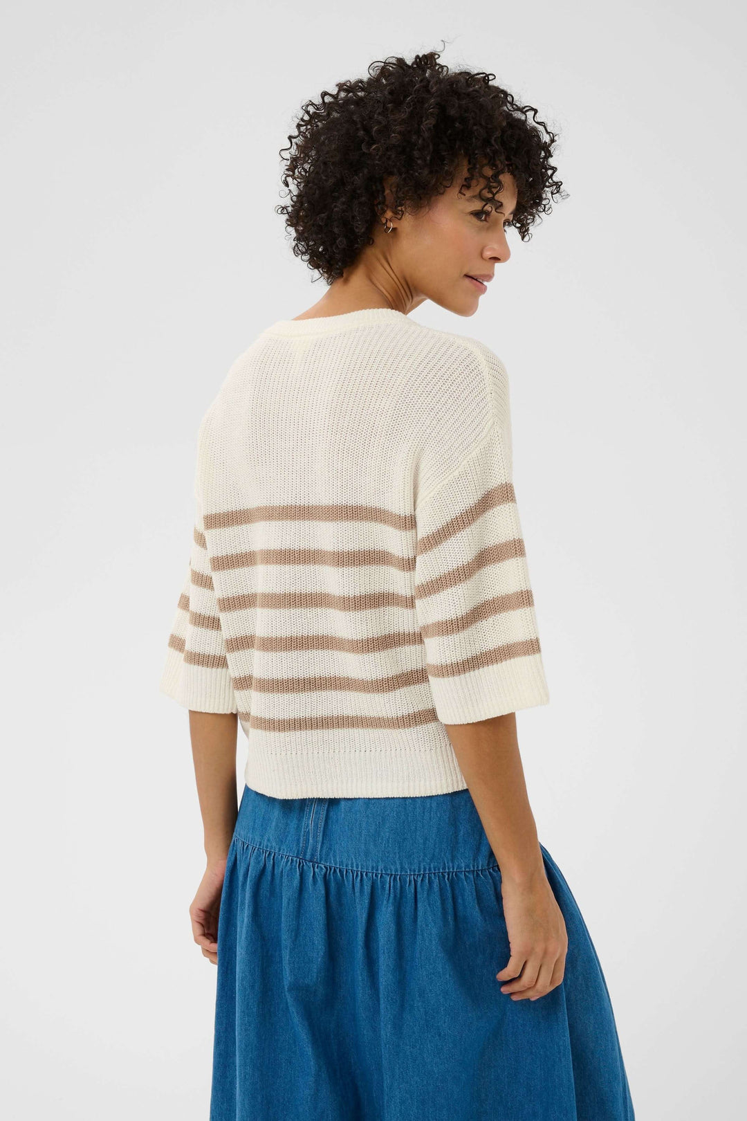 Femme portant le Tricot lin et coton Aliza avec manches courtes à rayures et une jupe bleue, style décontracté et actuel.