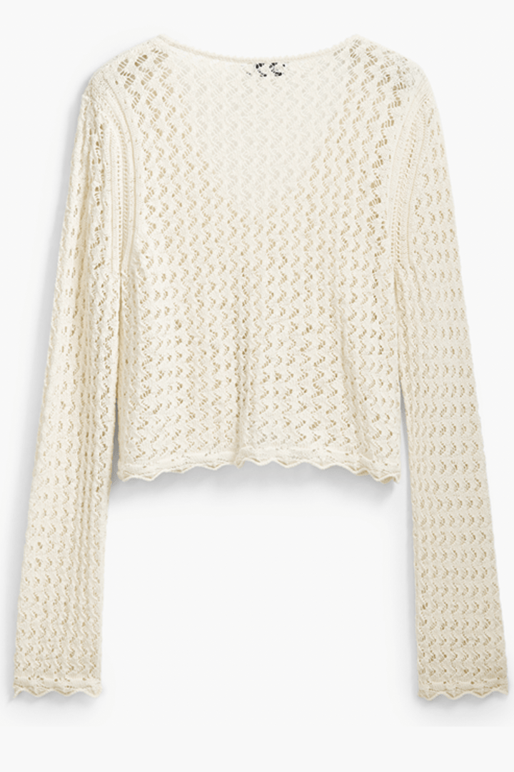 Tricot à motif ondulé, en tissu ajouré, encolure en V, manches longues, couleur crème.