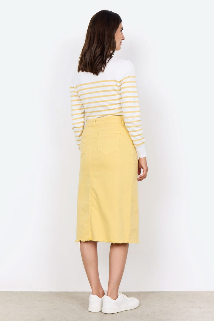 Femme en tricot rayé blanc et jaune, jupe jaune, vue arrière, style décontracté et élégant.