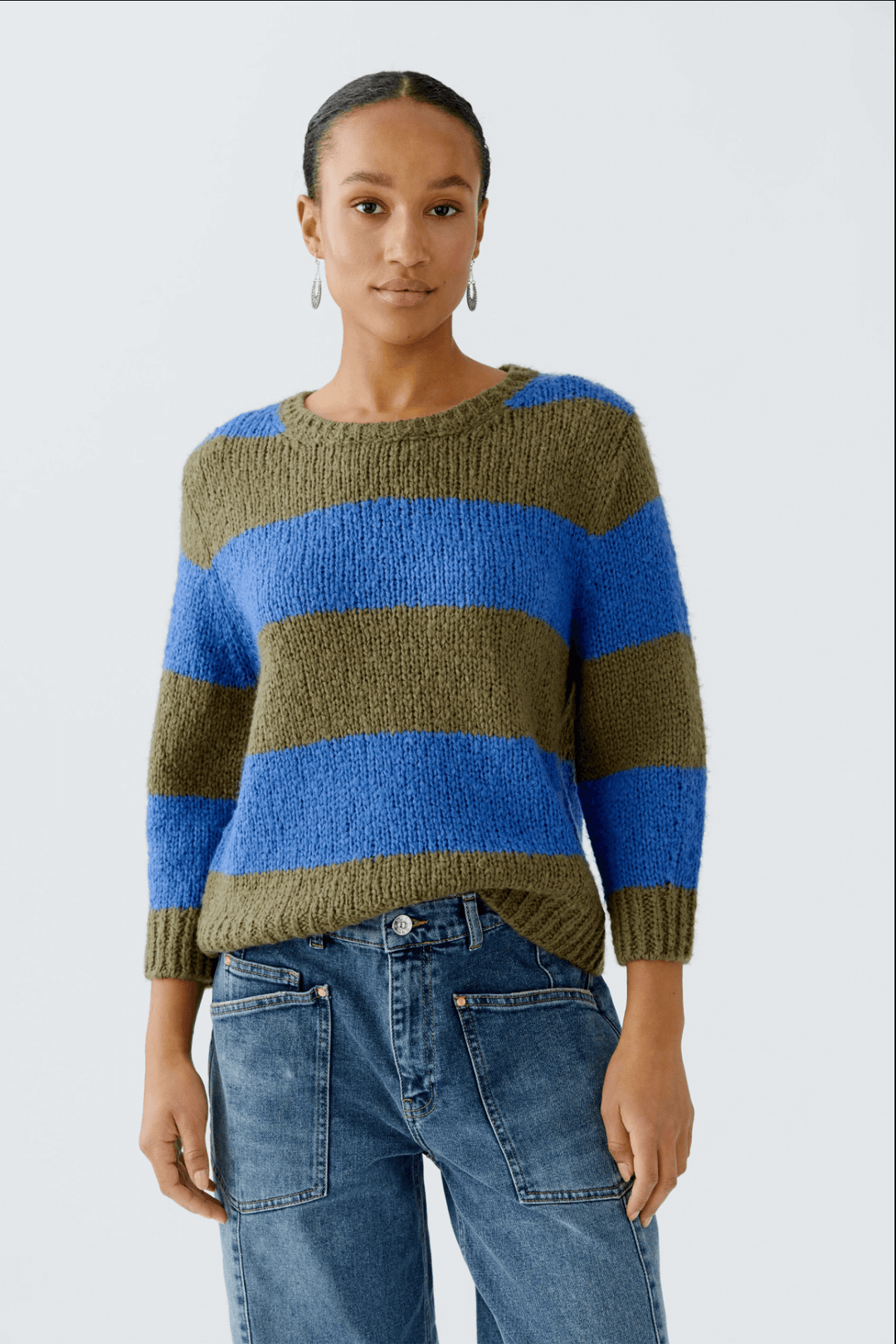 Femme portant un tricot rayures larges en laine et mohair avec manches 3/4, coupe décontractée et col ras du cou, style décontracté.