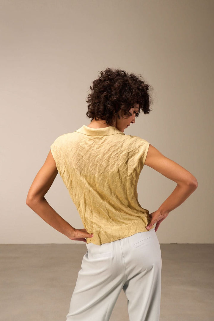 Veste légère à manches courtes jaune, col en V, aspect décontracté avec tissu légèrement froissé.