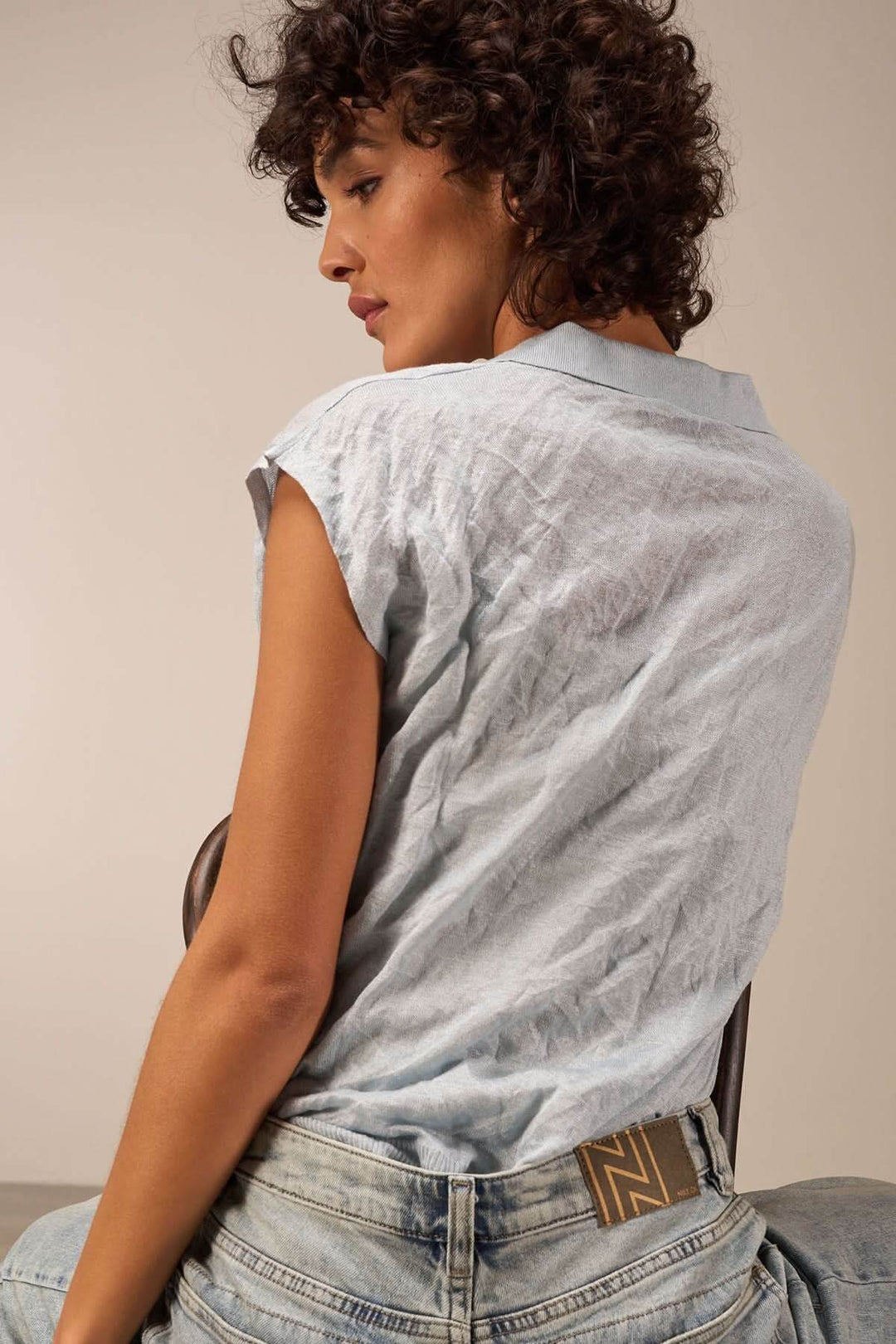 Veste légère à manches courtes, col en V, portée avec un look décontracté et élégant.