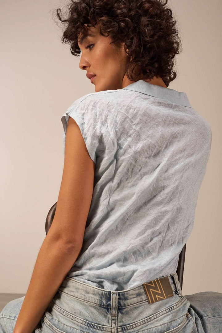 Veste légère à manches courtes, col en V, portée avec un look décontracté et élégant.